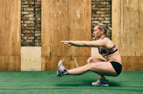 Vrouw voert pistol squat uit