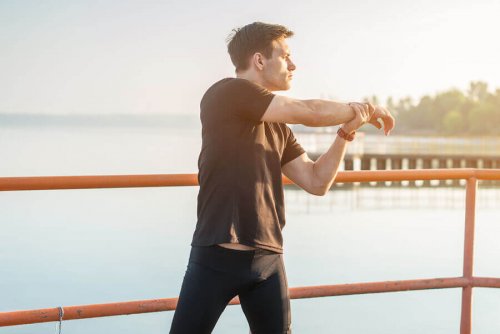 man die stretcht tegen spierpijn in de benen